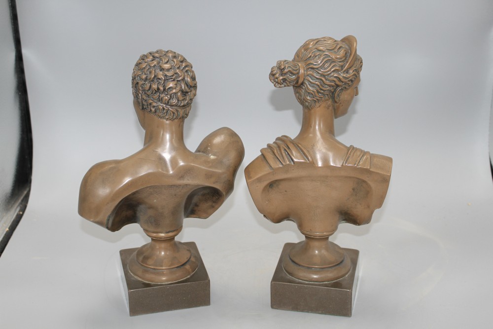 A pair of bronzed resin busts of Diana and Apollo, on integral bases, height 30cm